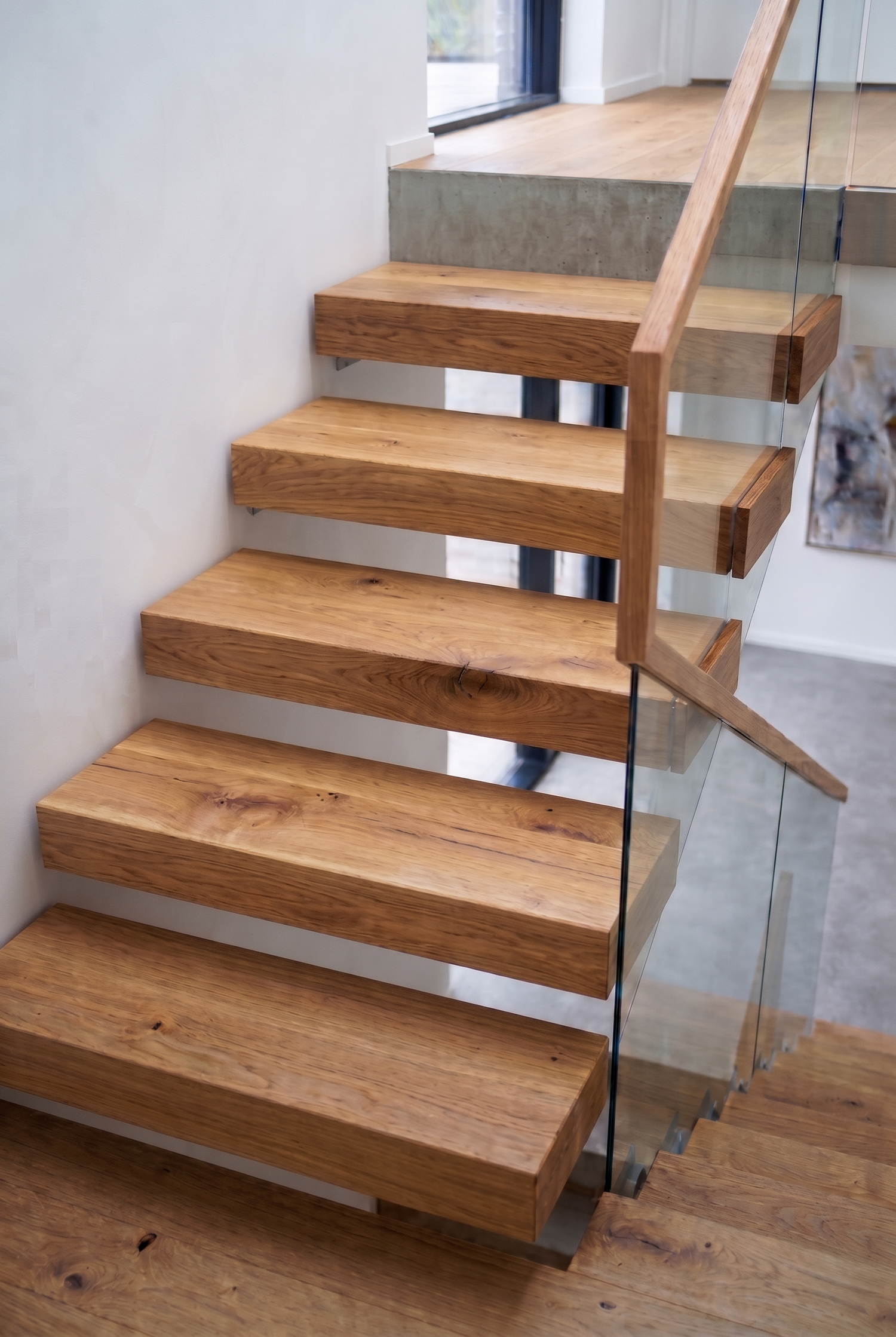 Escalier en bois naturel Beaulac intégré dans un projet d’architecture intérieure sur mesure et puissant esthétique avec aubier et noeuds